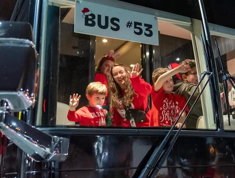 Kids waving from Bus #53 at night