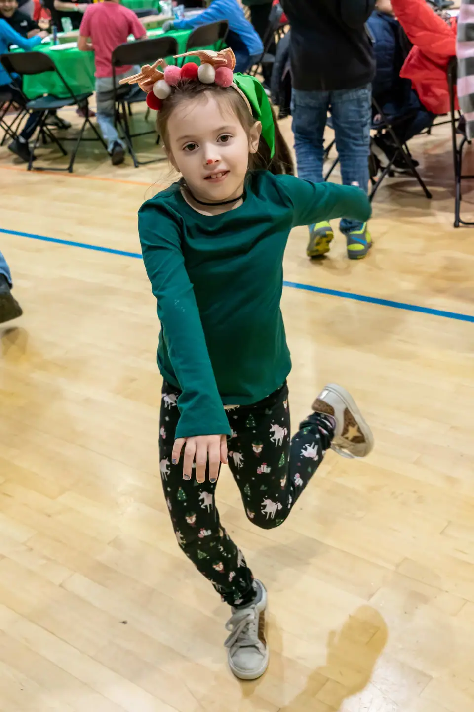A boy mid-dance-move on the gym floor