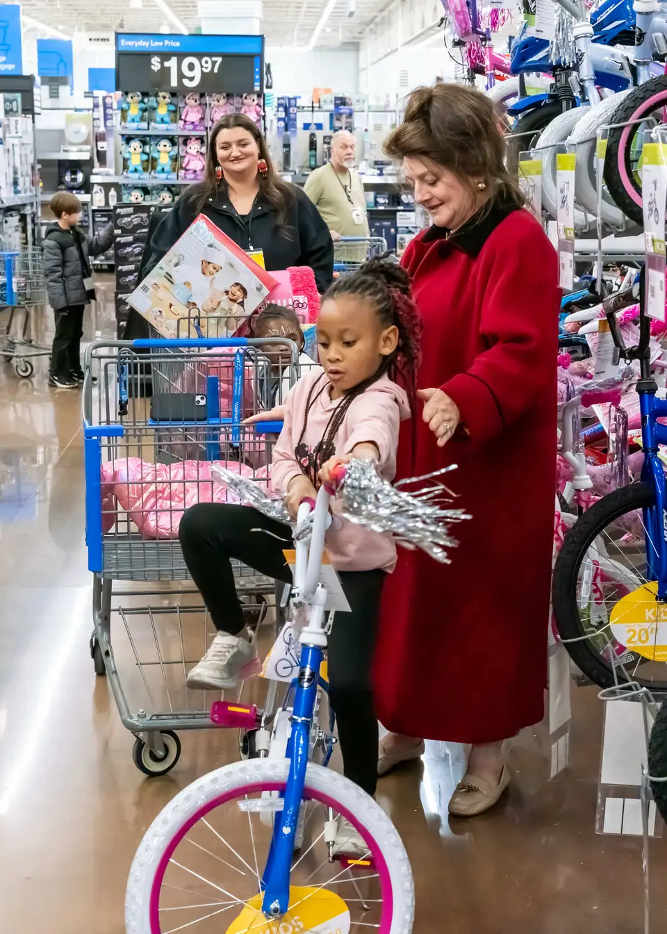 A little girl test-riding a new bike in the store